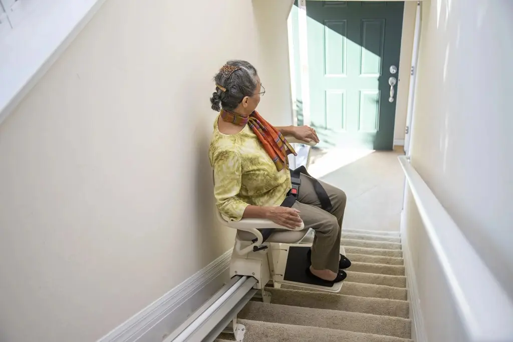 Senior using a stairlift chair for safe home mobility.